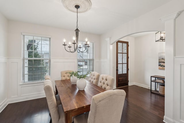 dining space with dark wood-type flooring and a chandelier