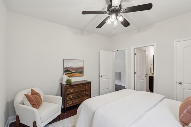 bedroom featuring dark hardwood / wood-style floors, ceiling fan, and ensuite bath