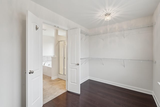 walk in closet with dark hardwood / wood-style flooring