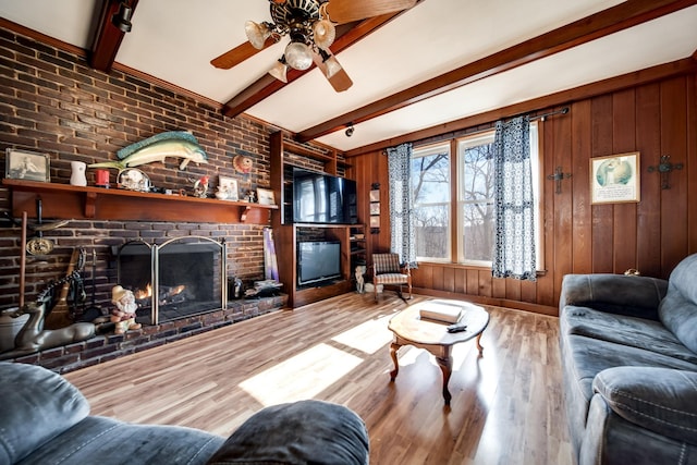 living room featuring a fireplace, wood-type flooring, wooden walls, and beamed ceiling