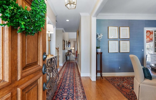 foyer entrance featuring crown molding and light hardwood / wood-style flooring