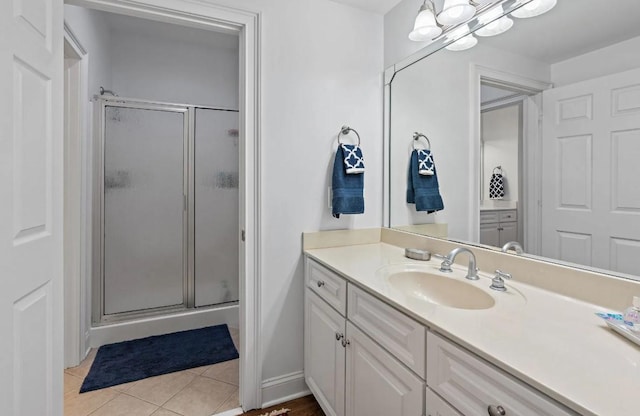 bathroom with an enclosed shower, vanity, tile patterned floors, and an inviting chandelier