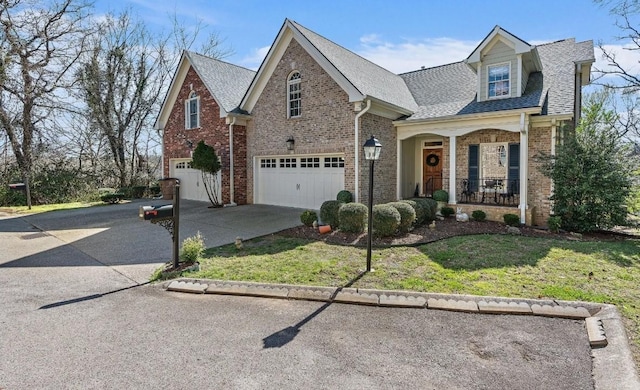 view of front of home with a garage, a front yard, and covered porch