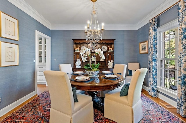 dining space featuring an inviting chandelier, ornamental molding, and hardwood / wood-style floors