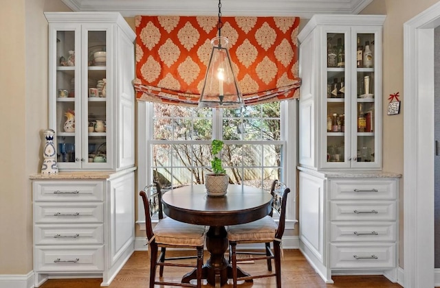 dining space with crown molding and wood-type flooring