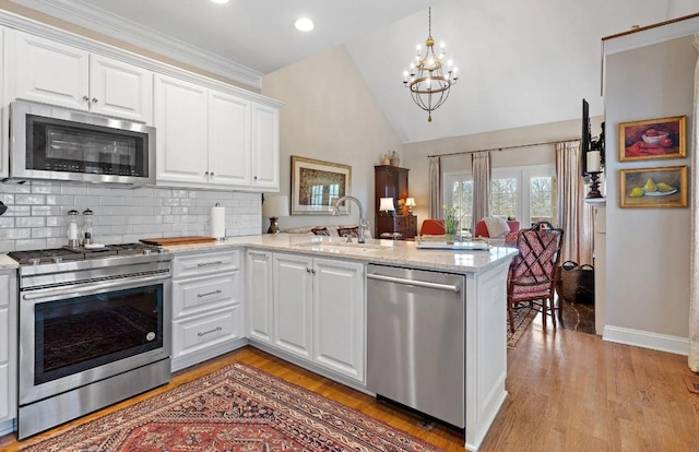 kitchen featuring white cabinetry, sink, kitchen peninsula, and appliances with stainless steel finishes