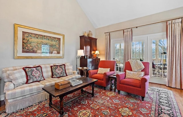 living room with high vaulted ceiling and light hardwood / wood-style floors