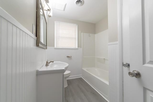 full bathroom featuring hardwood / wood-style flooring, vanity,  shower combination, and toilet