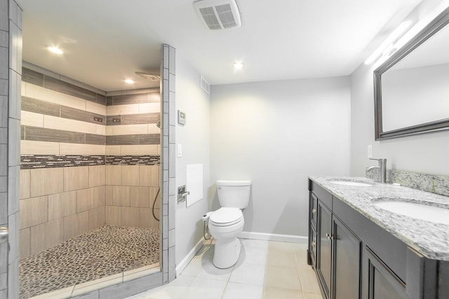 bathroom with vanity, tile patterned floors, toilet, and tiled shower