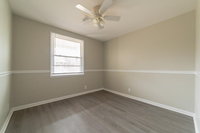 spare room featuring dark wood-type flooring and ceiling fan