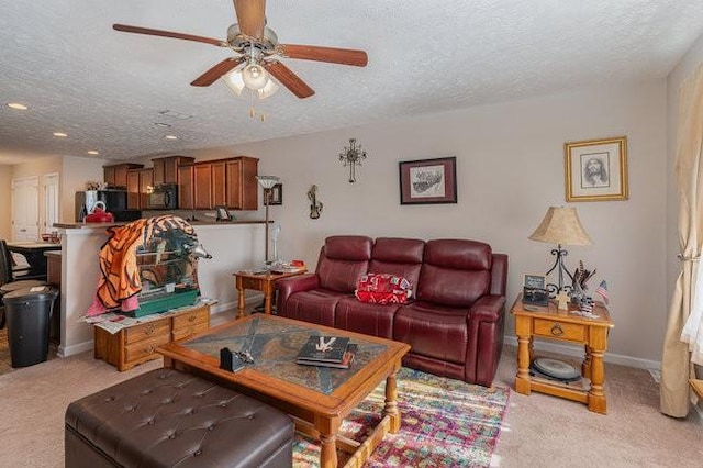 carpeted living room featuring ceiling fan and a textured ceiling