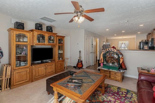 living room with light colored carpet, ceiling fan with notable chandelier, and a textured ceiling