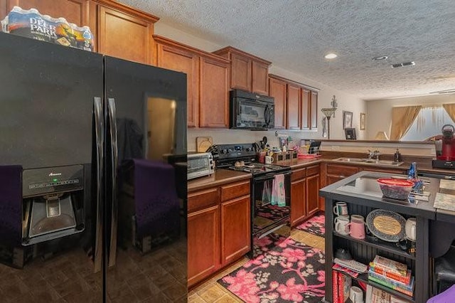 kitchen featuring kitchen peninsula, sink, a textured ceiling, and black appliances