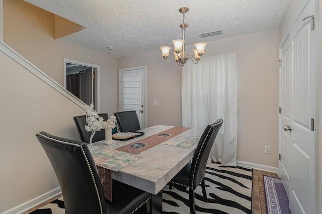 dining room featuring a notable chandelier and a textured ceiling