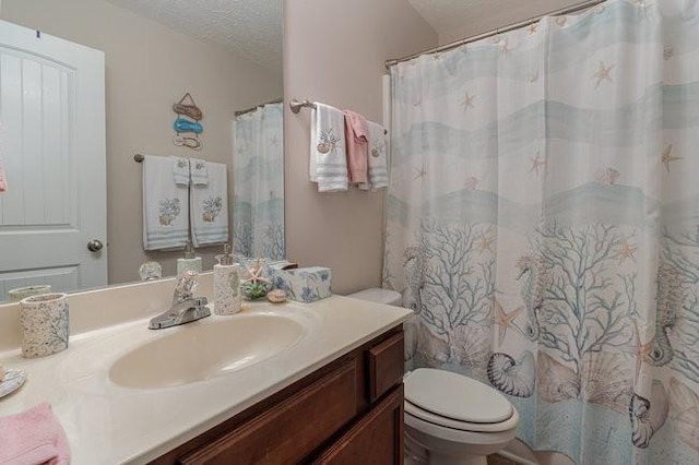 bathroom featuring vanity, toilet, and a textured ceiling