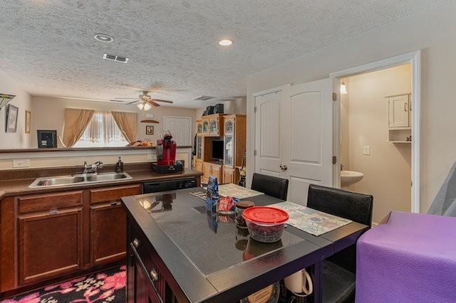 kitchen featuring dishwasher, sink, stainless steel counters, ceiling fan, and a textured ceiling