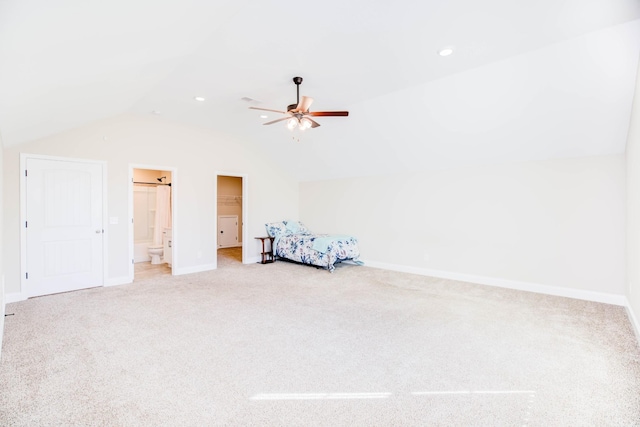 bedroom featuring ensuite bathroom, vaulted ceiling, light colored carpet, and ceiling fan