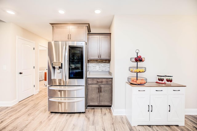 kitchen with tasteful backsplash, light hardwood / wood-style flooring, and stainless steel refrigerator