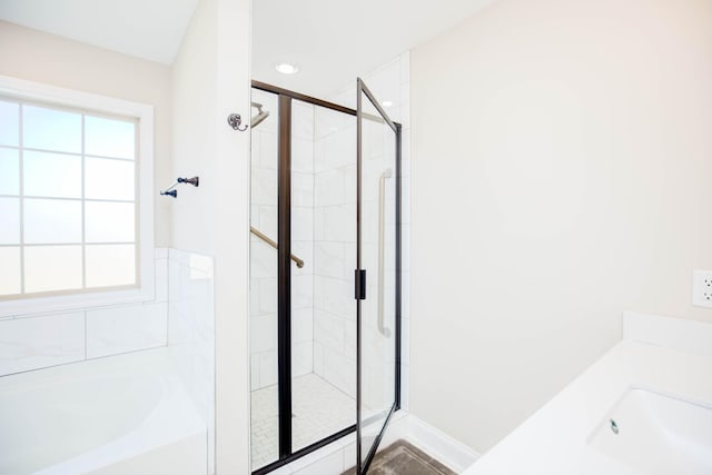 bathroom featuring plenty of natural light and separate shower and tub