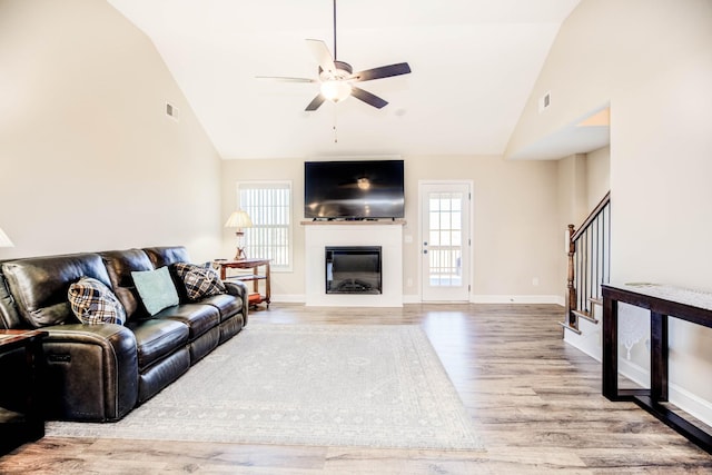 living room featuring lofted ceiling, light hardwood / wood-style floors, and ceiling fan