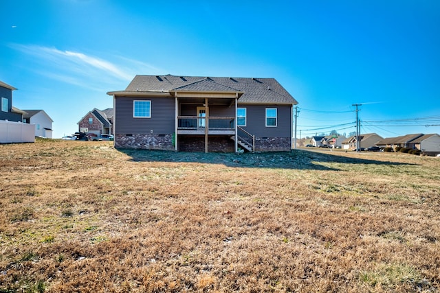 rear view of property featuring a yard