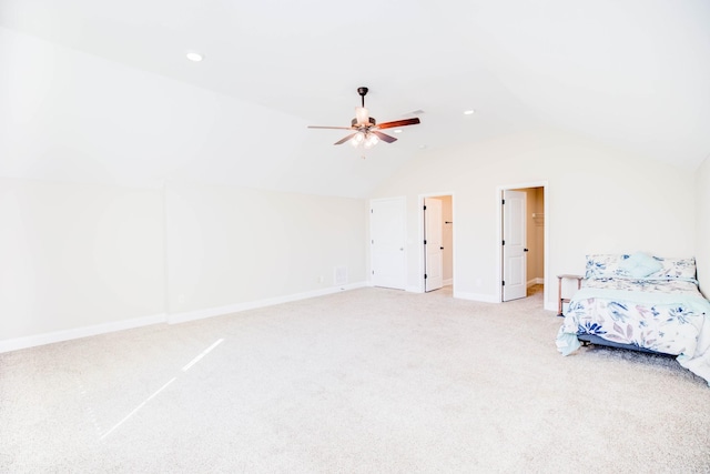 unfurnished bedroom featuring lofted ceiling, light colored carpet, and ceiling fan