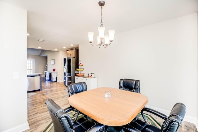 dining area featuring a notable chandelier and light wood-type flooring