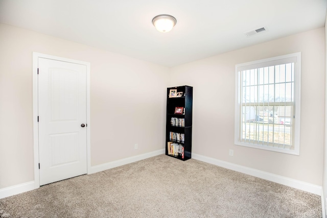 spare room featuring light colored carpet