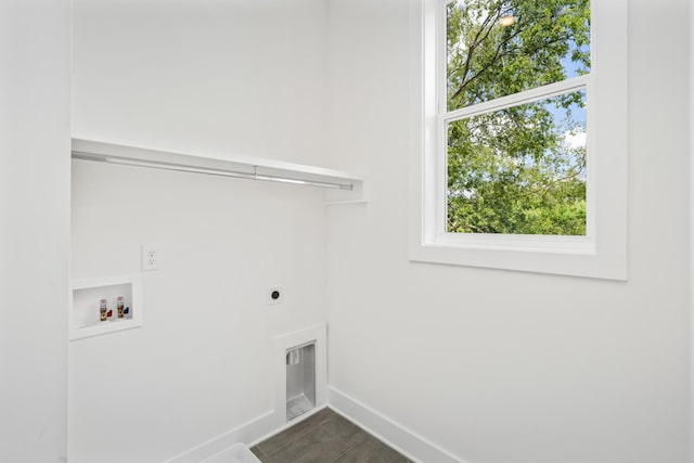 clothes washing area with hookup for a washing machine, electric dryer hookup, and dark tile patterned floors