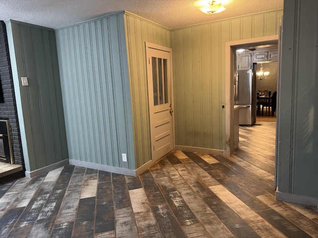 hallway with dark wood-type flooring and a textured ceiling