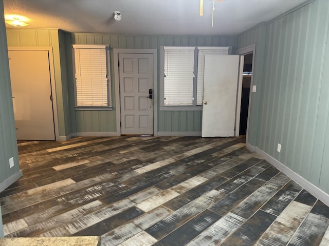 unfurnished room with dark wood-type flooring and a textured ceiling