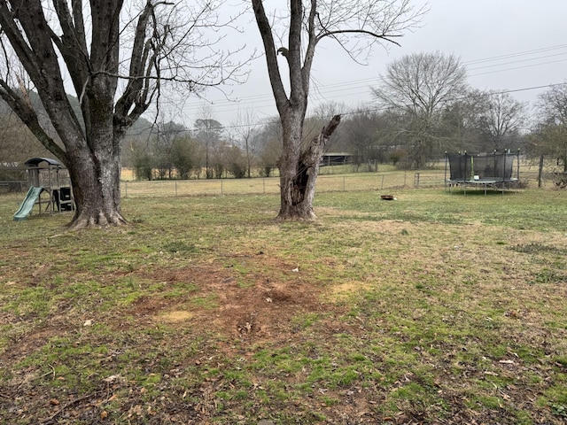 view of yard with a playground and a trampoline