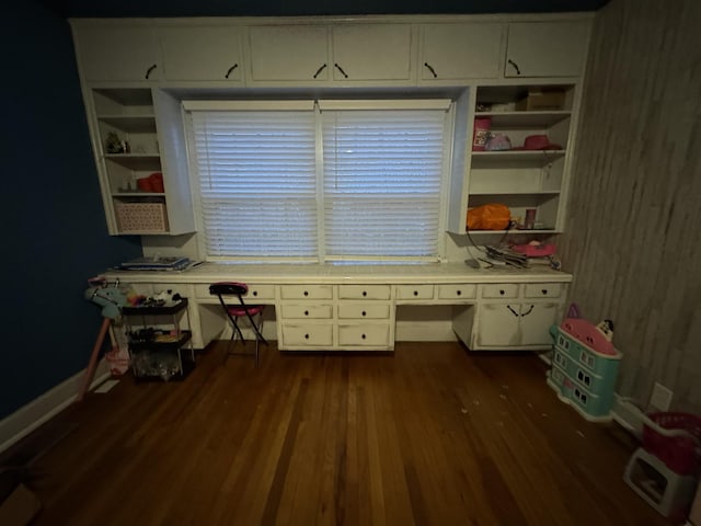 interior space featuring dark hardwood / wood-style floors, built in desk, and built in shelves