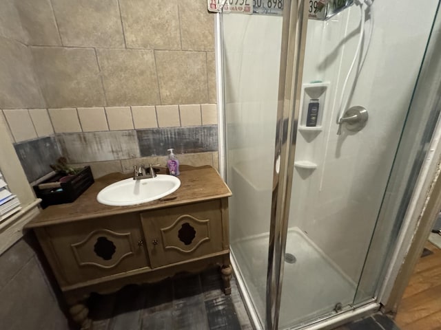 bathroom featuring vanity, wood-type flooring, and a shower with shower door