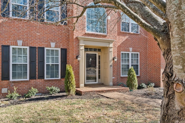 entrance to property featuring a lawn