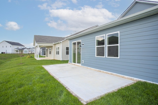 rear view of property featuring a lawn and a patio