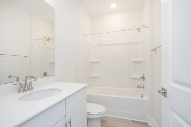 full bathroom with hardwood / wood-style flooring, vanity, shower / washtub combination, and toilet