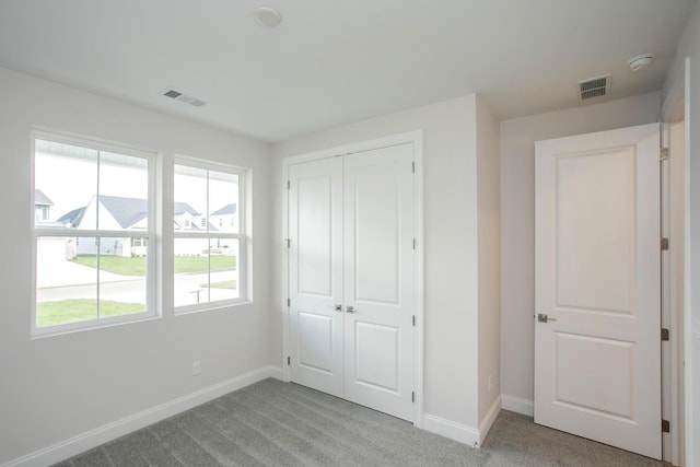 unfurnished bedroom featuring a closet and light carpet