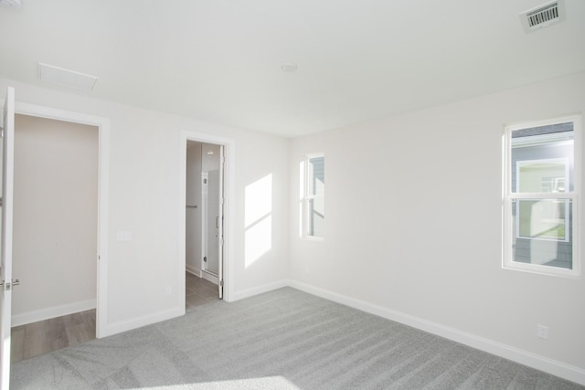 empty room featuring light colored carpet and a wealth of natural light