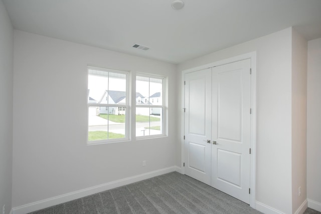 unfurnished bedroom featuring carpet floors and a closet