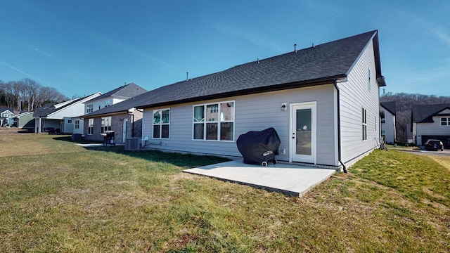 rear view of house with central AC, a lawn, and a patio