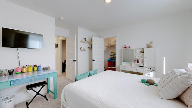 carpeted bedroom featuring a spacious closet and a closet