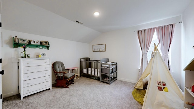 carpeted bedroom featuring a nursery area and lofted ceiling