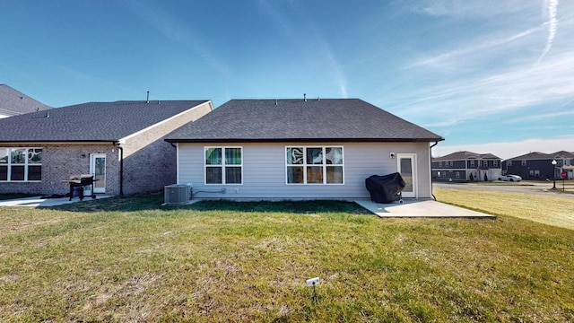 rear view of house featuring a patio, cooling unit, and a lawn