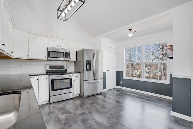 kitchen with stainless steel appliances, vaulted ceiling, decorative backsplash, and white cabinets