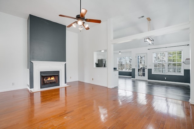 unfurnished living room featuring ceiling fan, lofted ceiling, and hardwood / wood-style floors