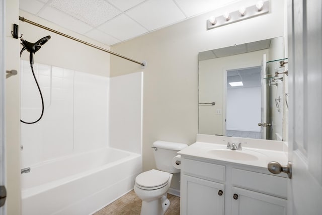 full bathroom with a drop ceiling, vanity, bathing tub / shower combination, and toilet