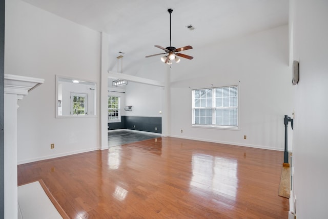 unfurnished living room with hardwood / wood-style floors, high vaulted ceiling, and ceiling fan