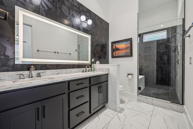 bathroom featuring vanity, a shower with door, and toilet