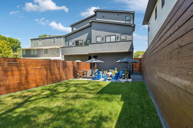 rear view of property featuring a yard and a patio area